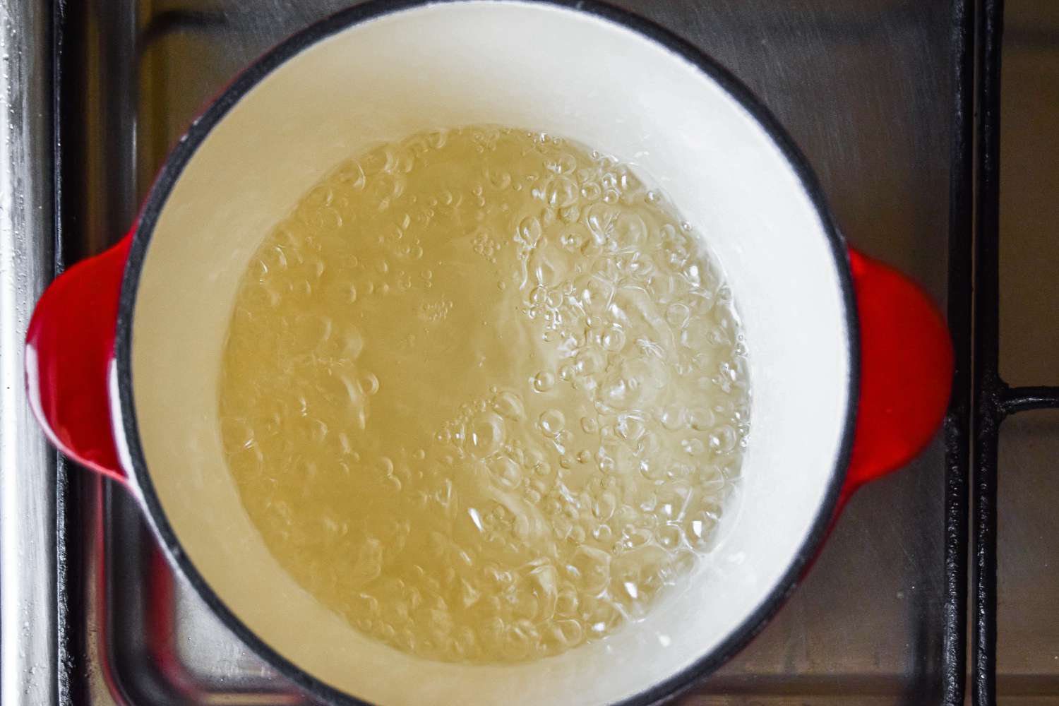 A dutch oven with simmering water and sugar 