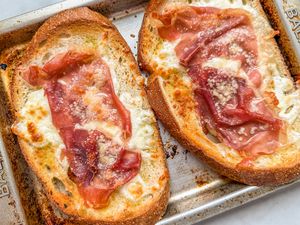 Overhead view of two pieces of 4-ingredient ham and cheese toast on a toaster oven tray