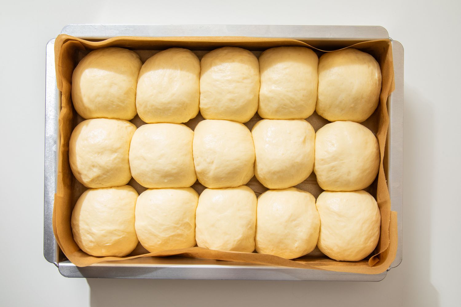 Proofed salted honey rolls in a baking pan (rolls doubled in size)