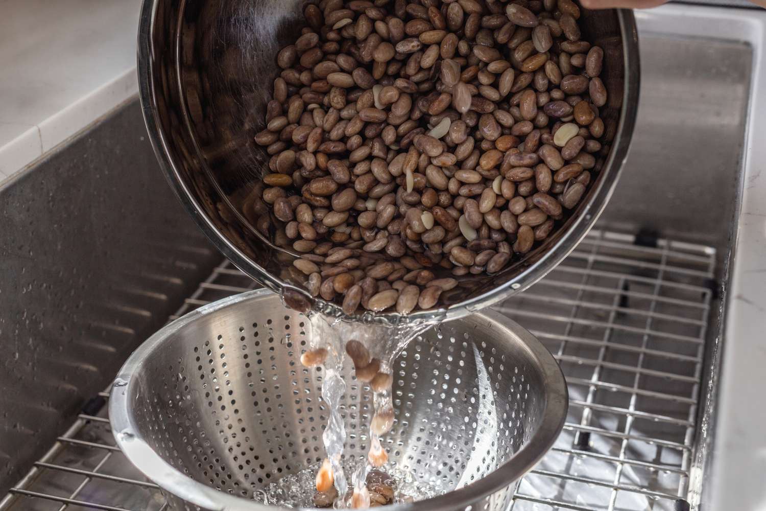 Pouring beans into a colander to make a cowboy beans recipe.
