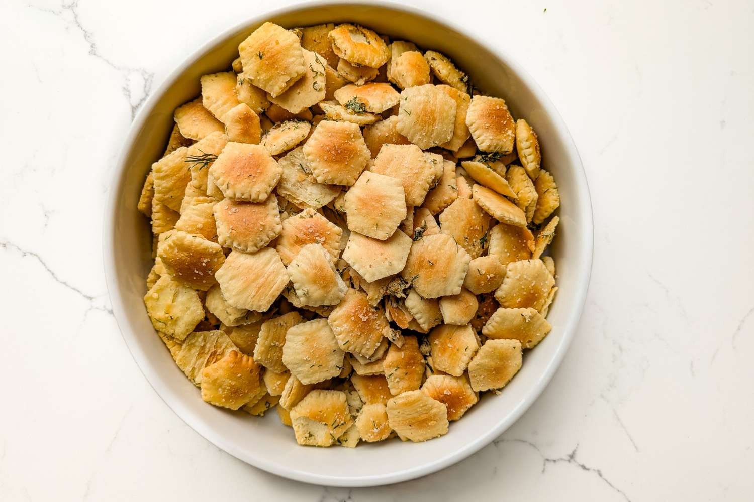 A bowl filled with hexagonal crackers positioned on a white surface
