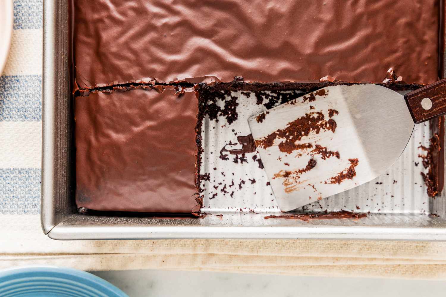 Chocolate depression cake in a baking pan with a few pieces already cut out
