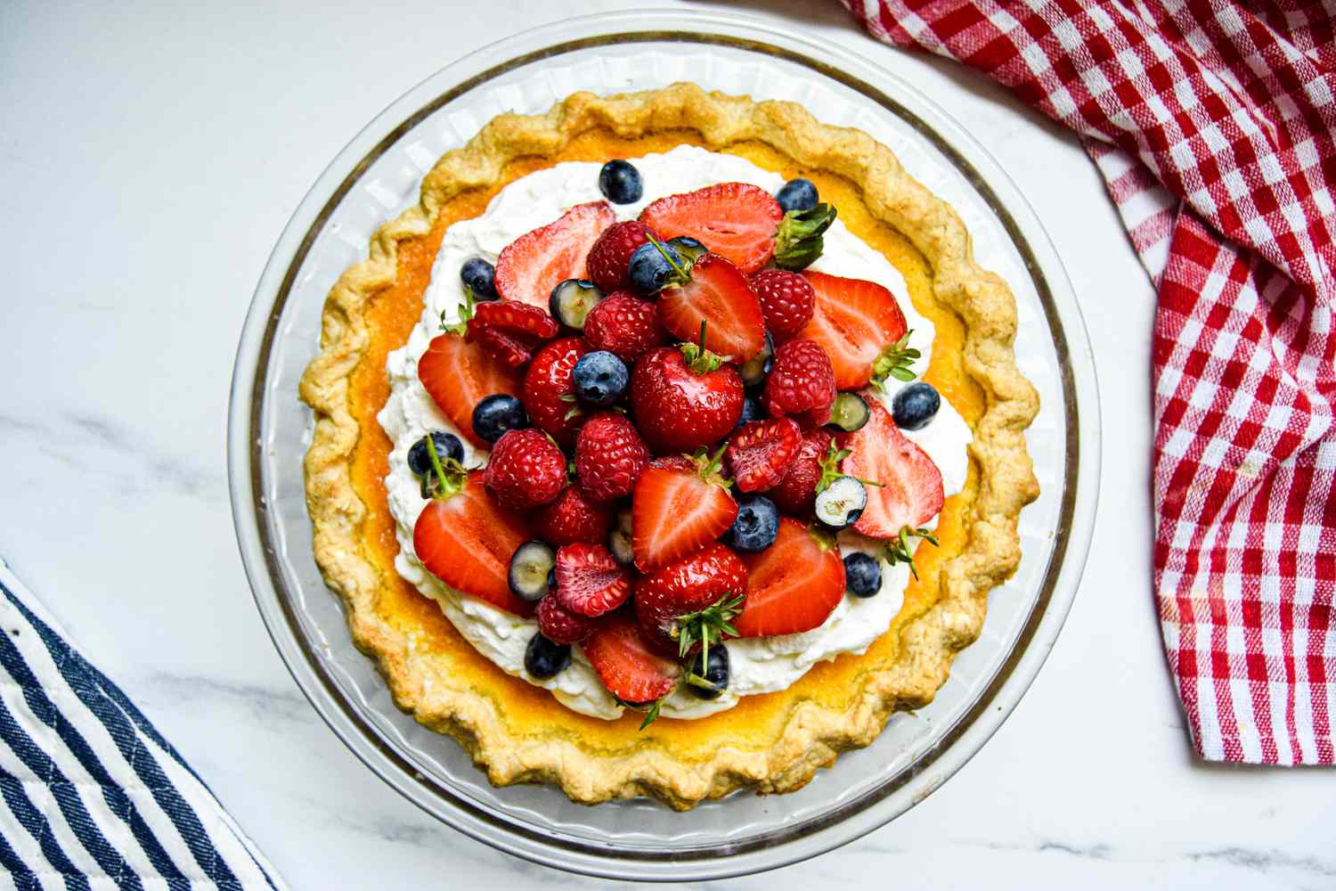 Overhead view of a buttermilk pie topped with berries.
