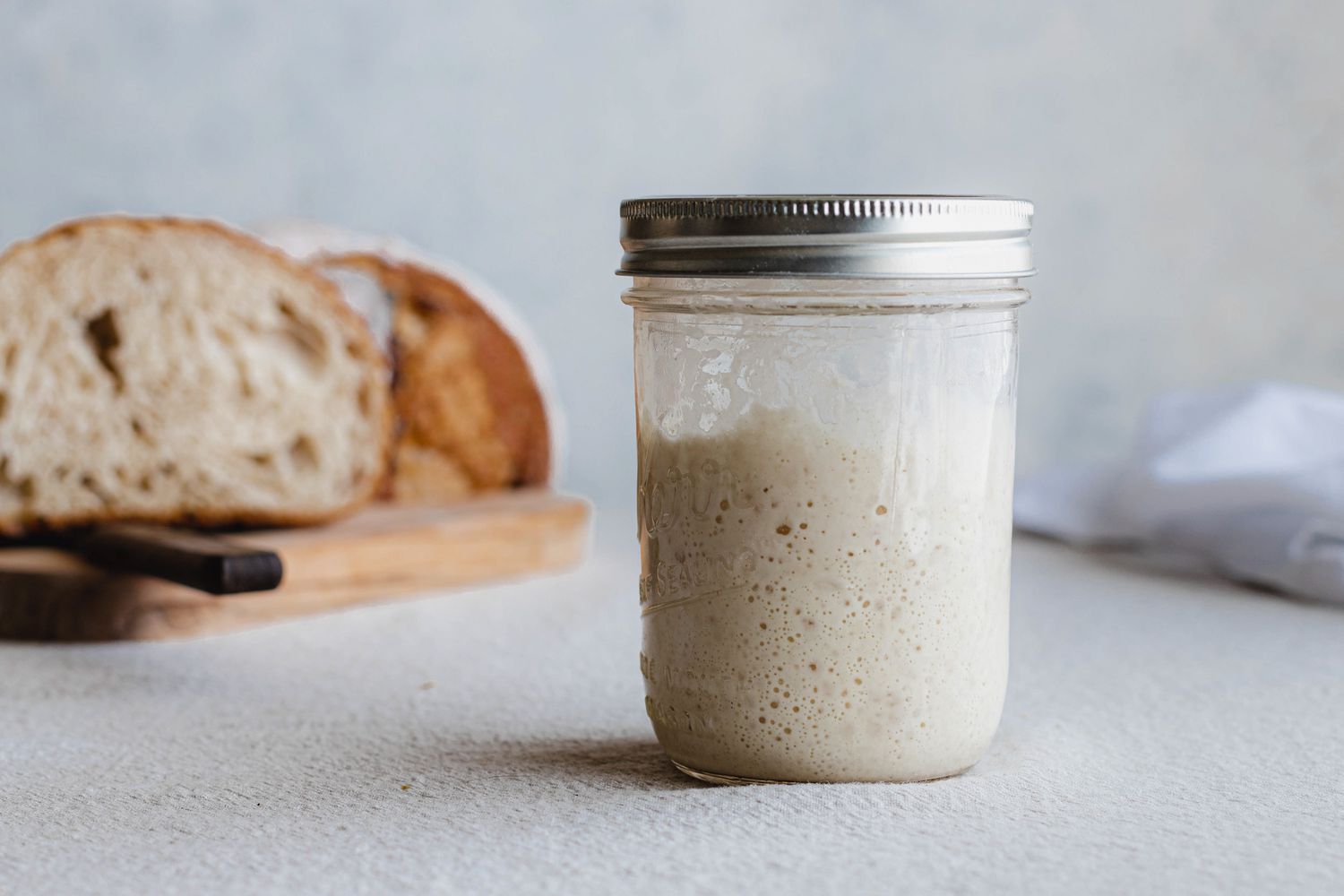 Side view of a mason jar filled with a simple sourdough starter