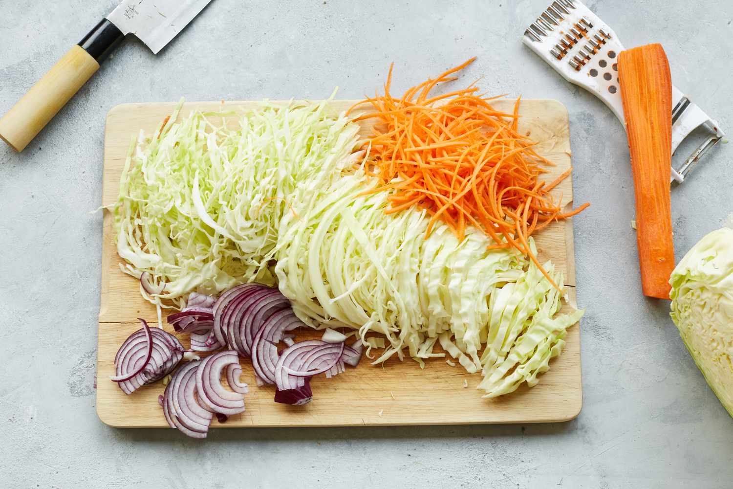 Thinly Sliced Cabbage, Onion, and Carrots on Cutting Board for Chào Gá (Vietnamese Rice Porridge) 