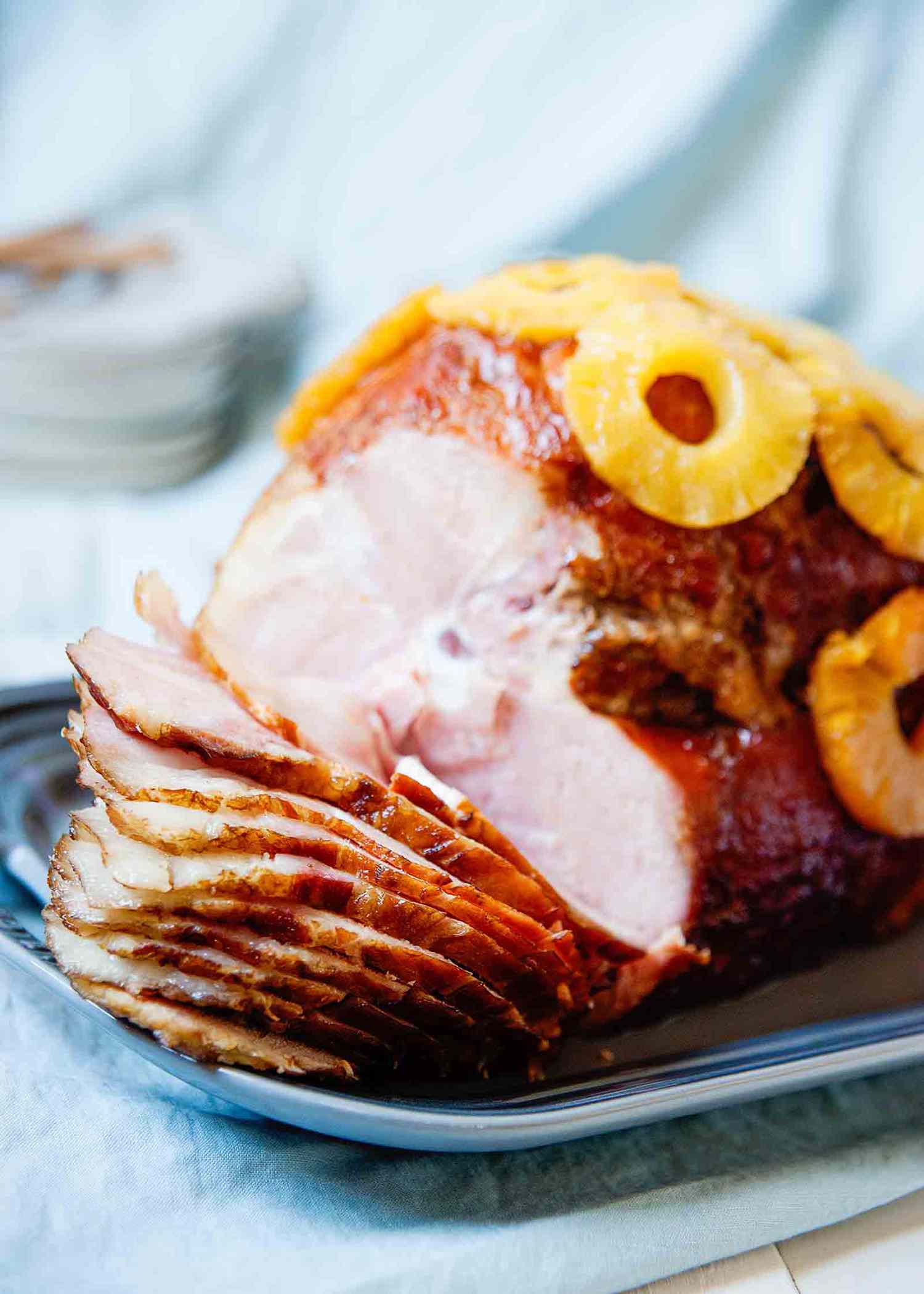 How to Bake a Ham - partially sliced ham covered in pineapple rings