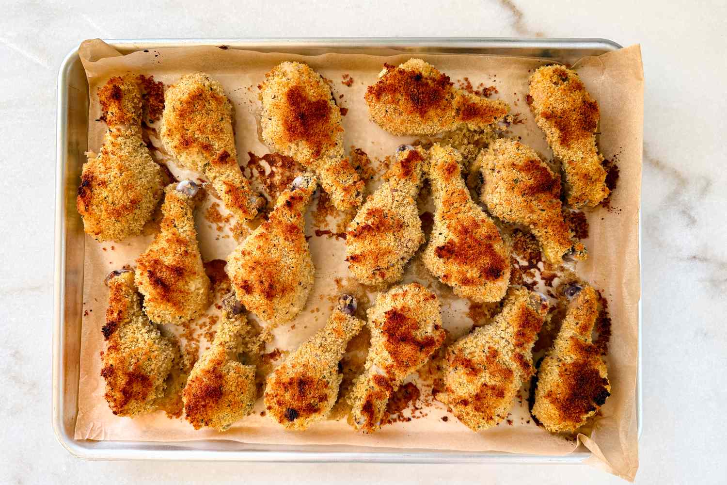 Overhead shot of a baking sheet with crispy breaded and baked chicken thighs