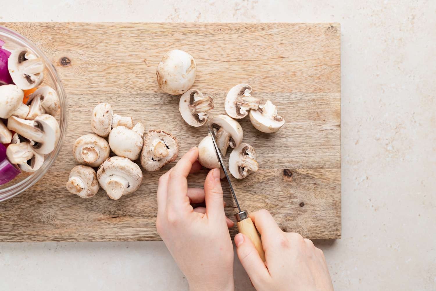 Slicing mushrooms to make shish kabobs.