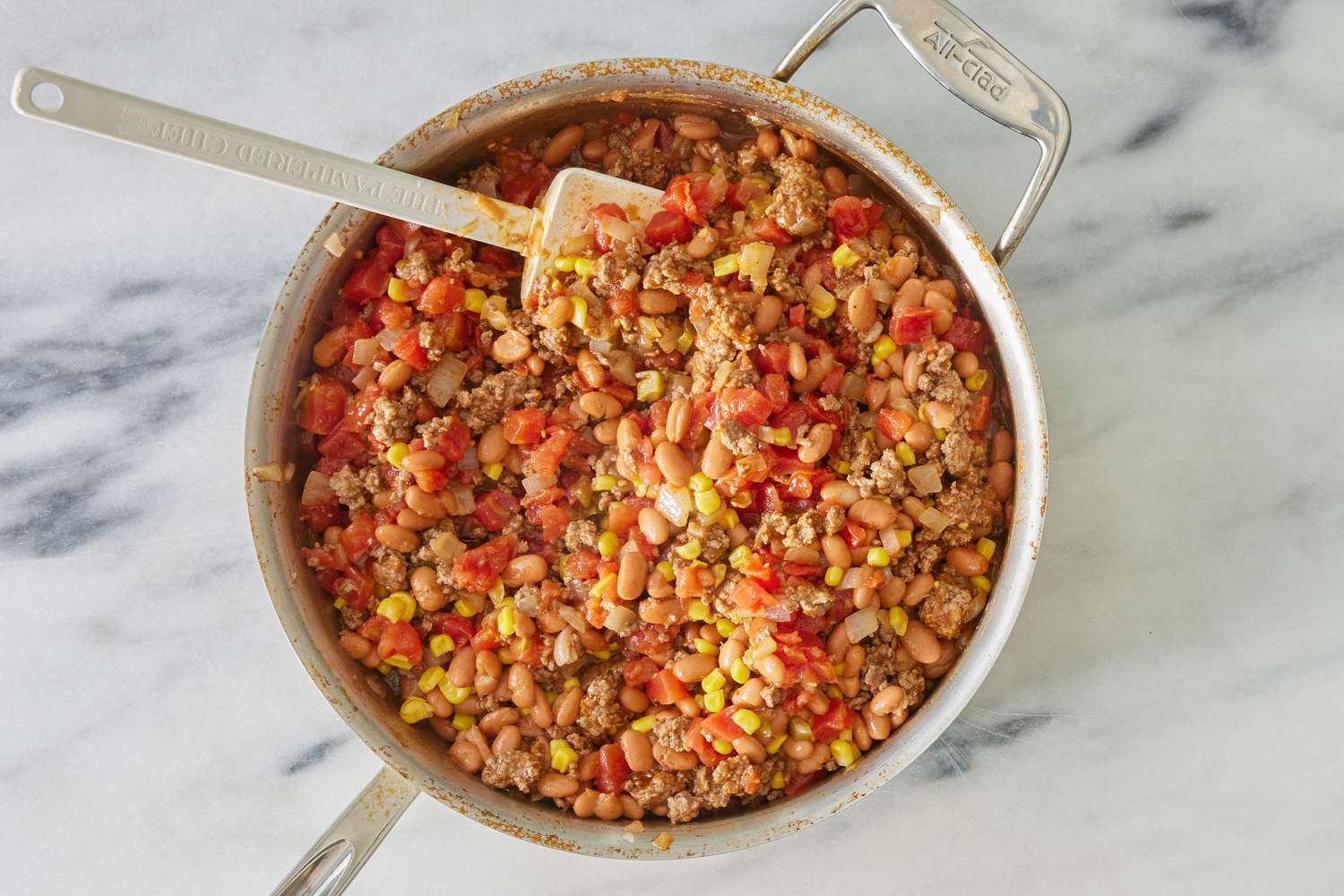 canned tomatoes and beans added to pot with ground beef and onions for cowboy casserole recipe