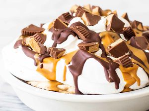 Chocolate penaut butter pie topped with whipped cream and peanut butter cups.