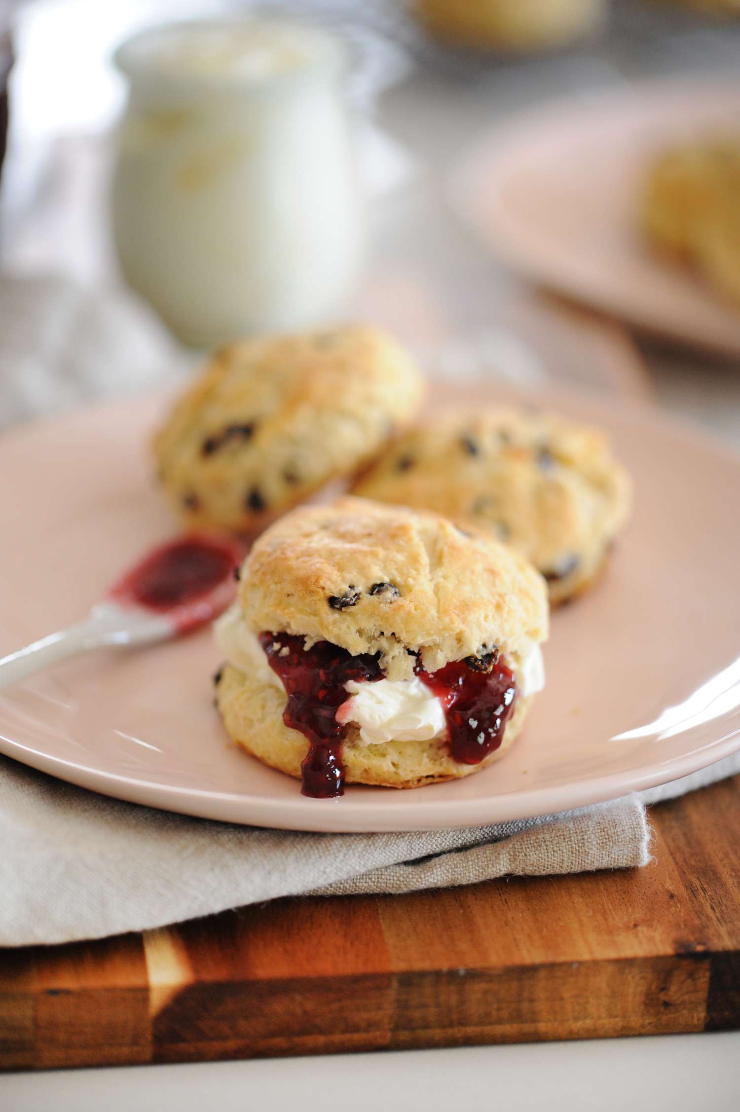 Real Irish Scones spread with jam and set on a plate.