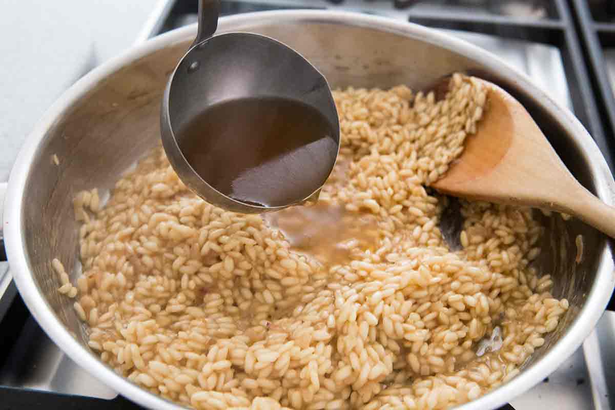 ladle vegetable stock into the risotto a half cup at a time