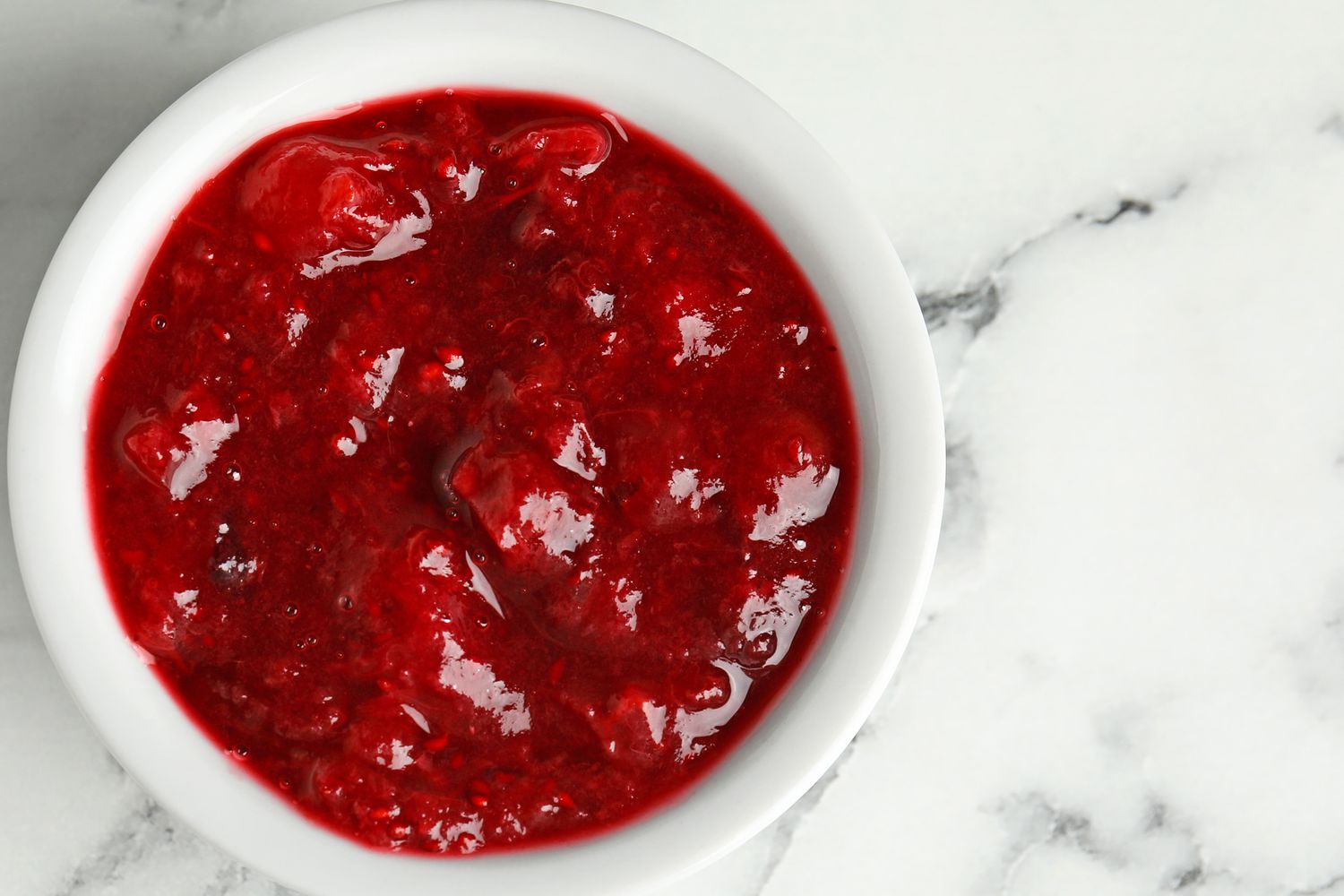 Overhead photo of cranberry sauce in a white ceramic ramekin