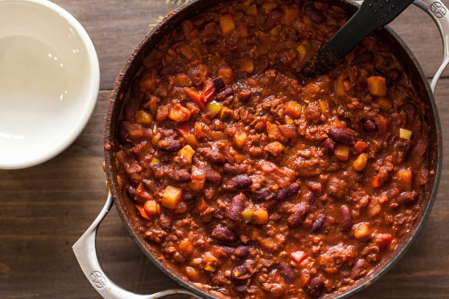 A pot with chili on a wooden surface