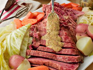 Crockpot Corned Beef - drizzling mustard on sliced corned beef