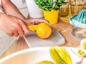 hands cutting a lemon