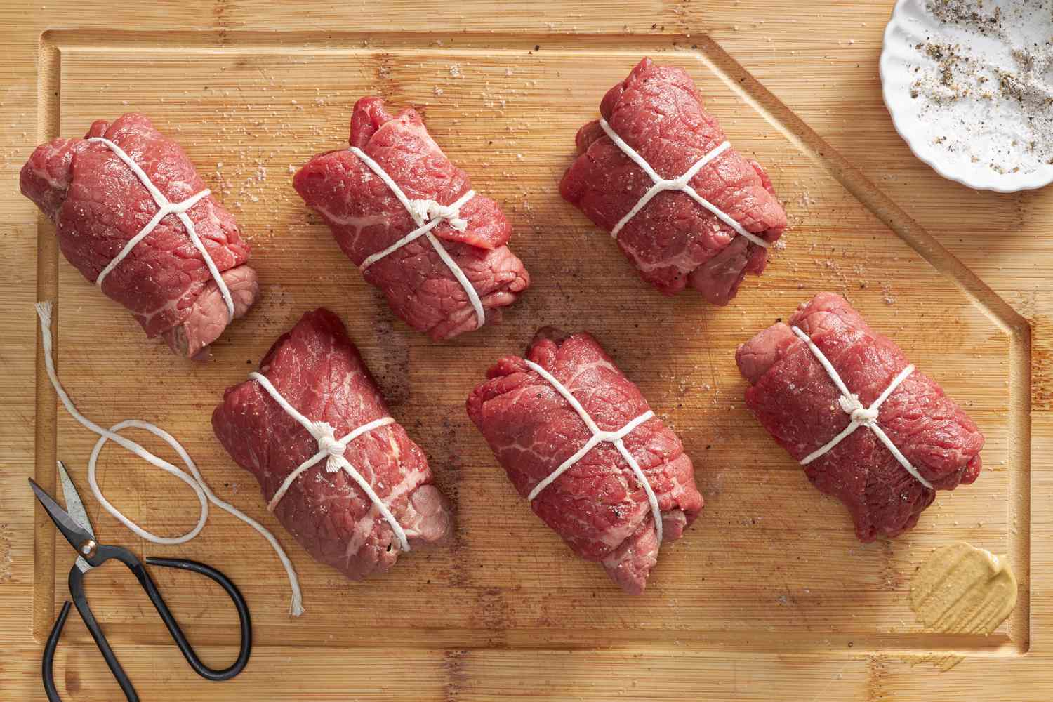 German rouladen wrapped in kitchen twine on a cutting board