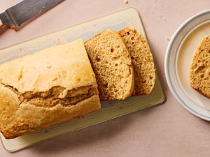 Overhead view of a loaf of retro peanut butter bread next to a plate with a slice