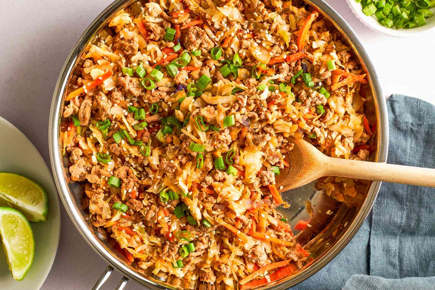 Overhead view of a pan of egg roll in a bowl with a wooden spoon
