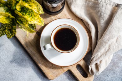 Overhead shot of a cup of coffee sitting on a matching saucer