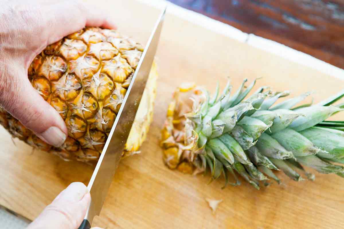 lay pineapple on its side and cut off the top