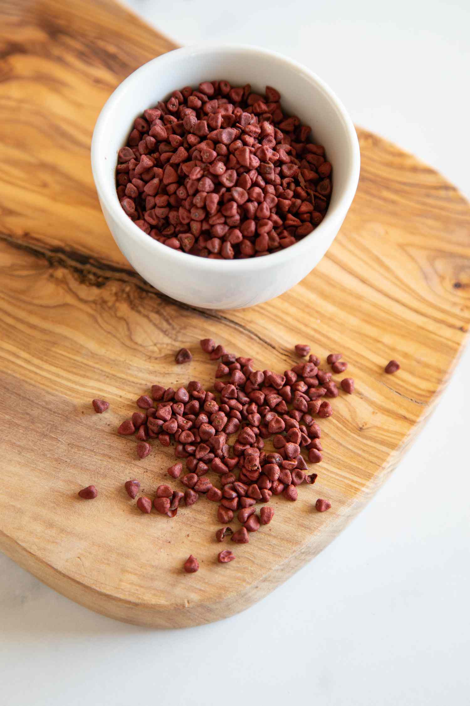 Annatto seeds in a white bowl