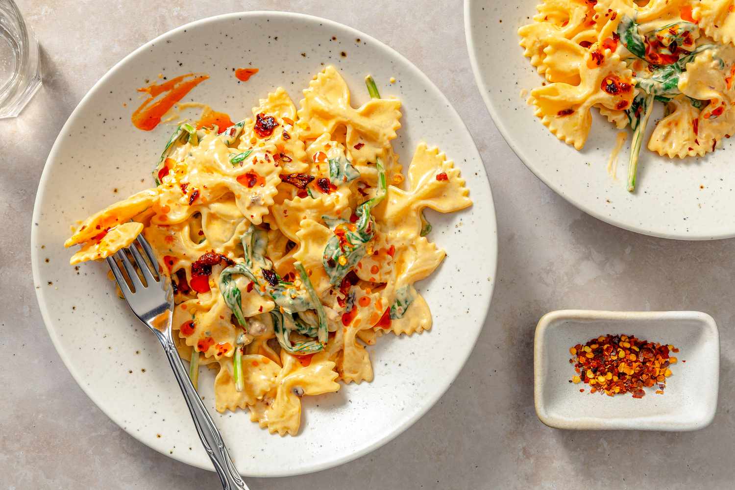 A plate of pasta with chili crisp on a light-colored surface