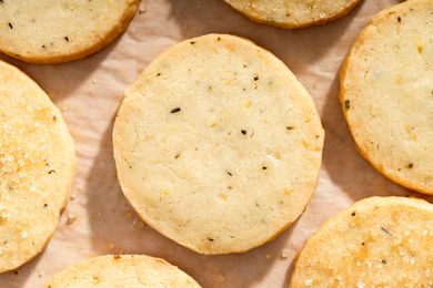 Round shortbread cookies with rosemary and lemon topped with sugar granules arranged on a baking sheet