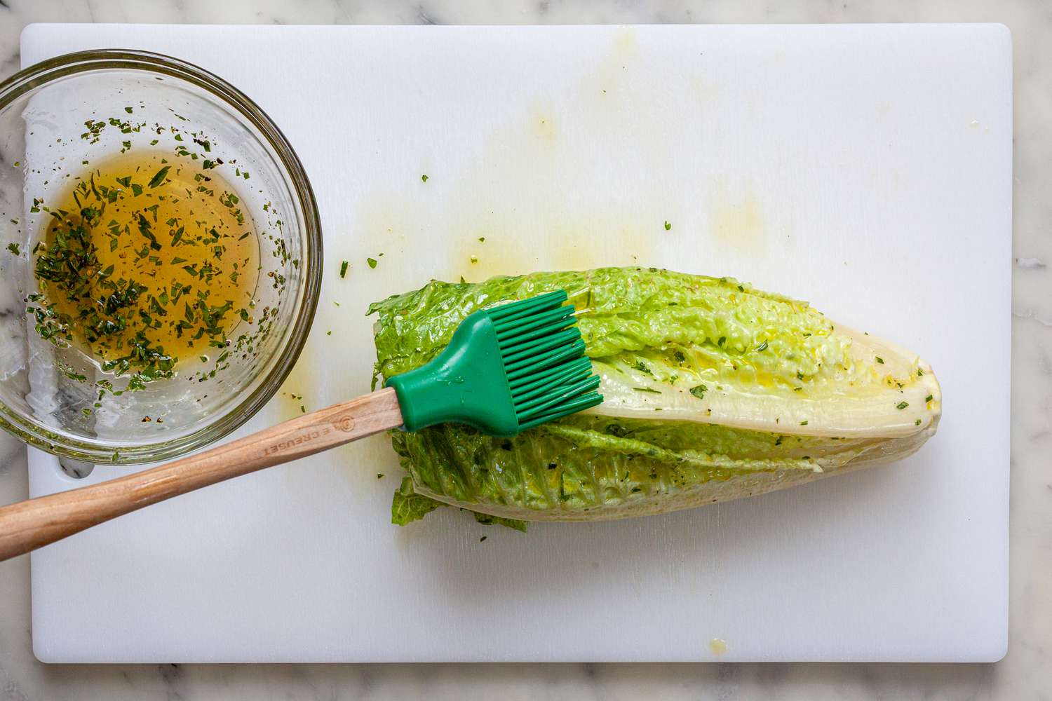 Brushing dressing on romaine lettuce.