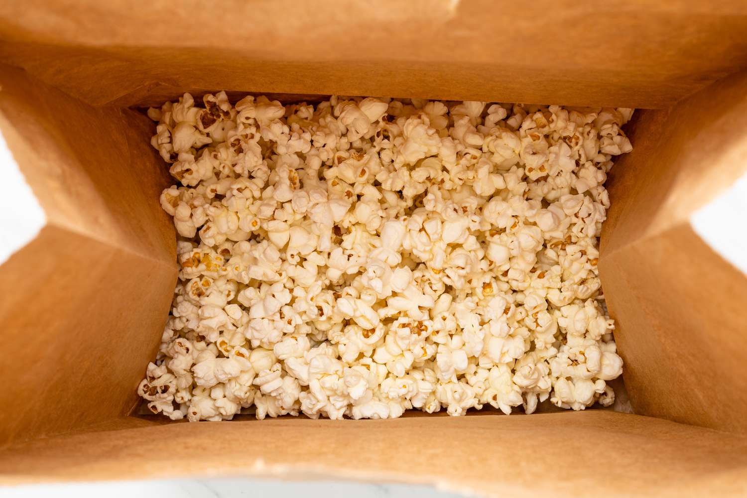 place popcorn in paper bag