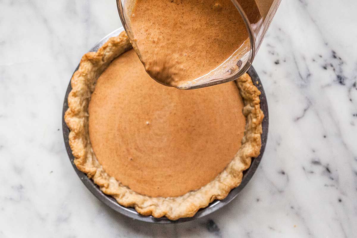 Pouring custard inot a pie crust to bake