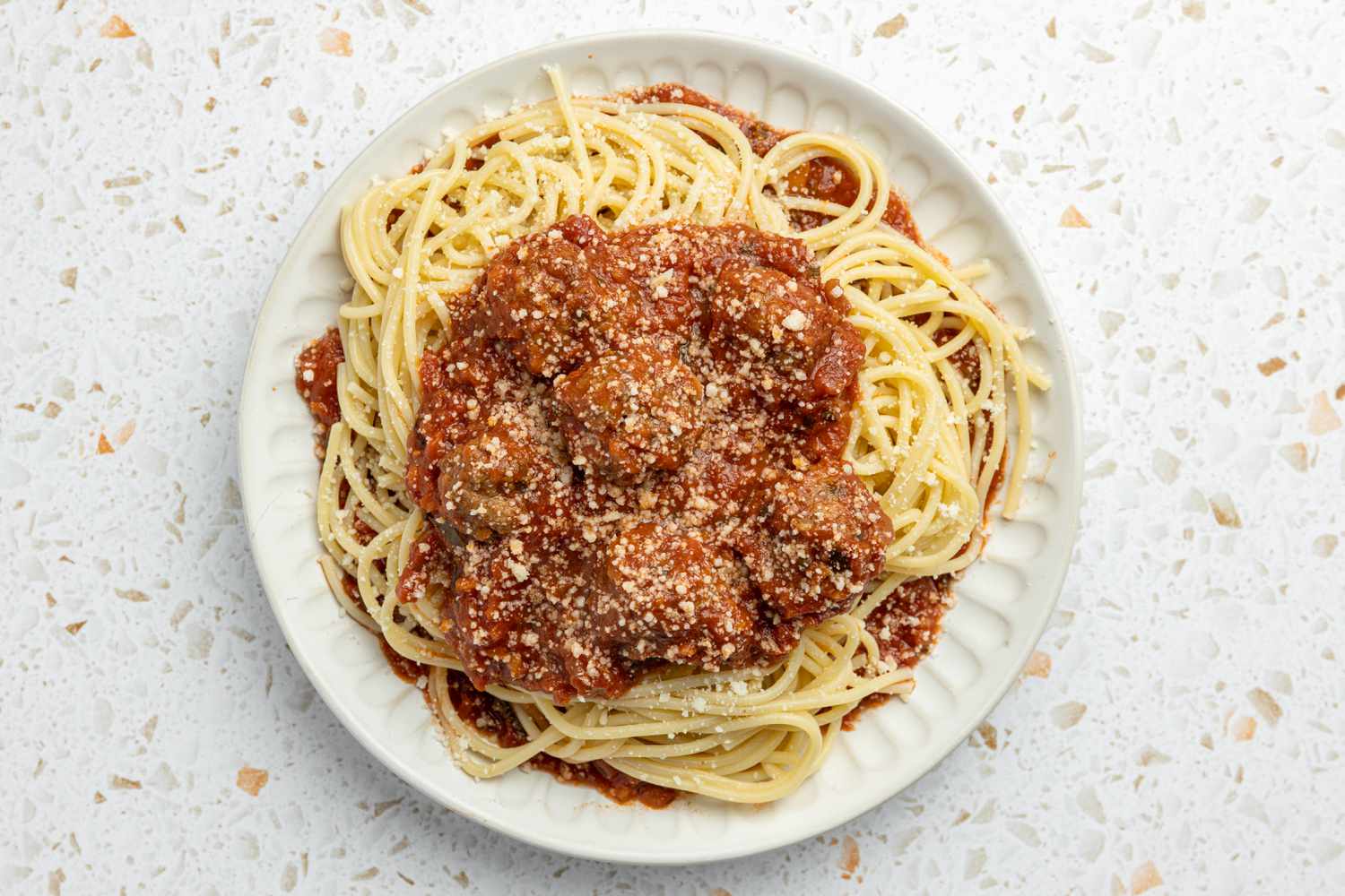 Plate of Spaghetti and Meatballs Topped With Parmesan 