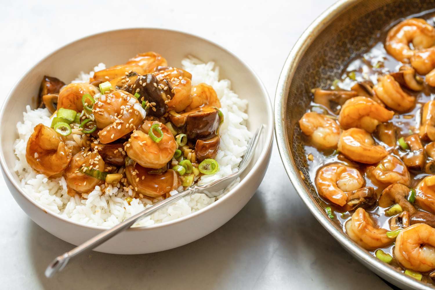 Shrimp and Mushroom Stir Fry in a Bowl Served with Rice, Next to a Skillet with More Stir Fry 