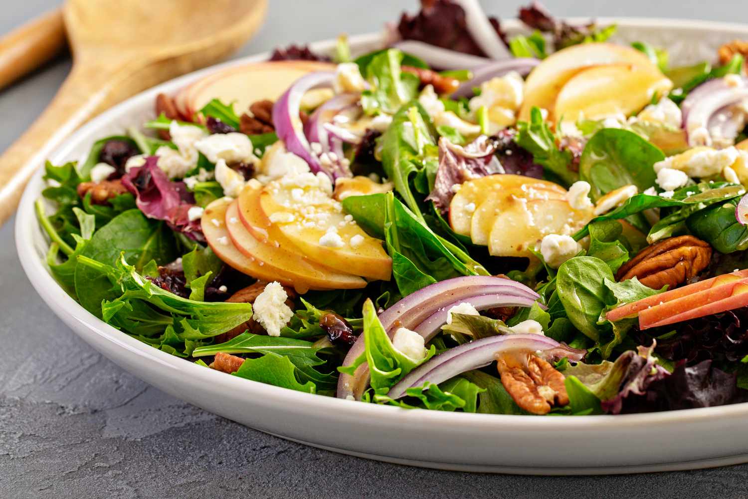 Winter salad with apple, red onion, pecans, cranberries, and spring mix