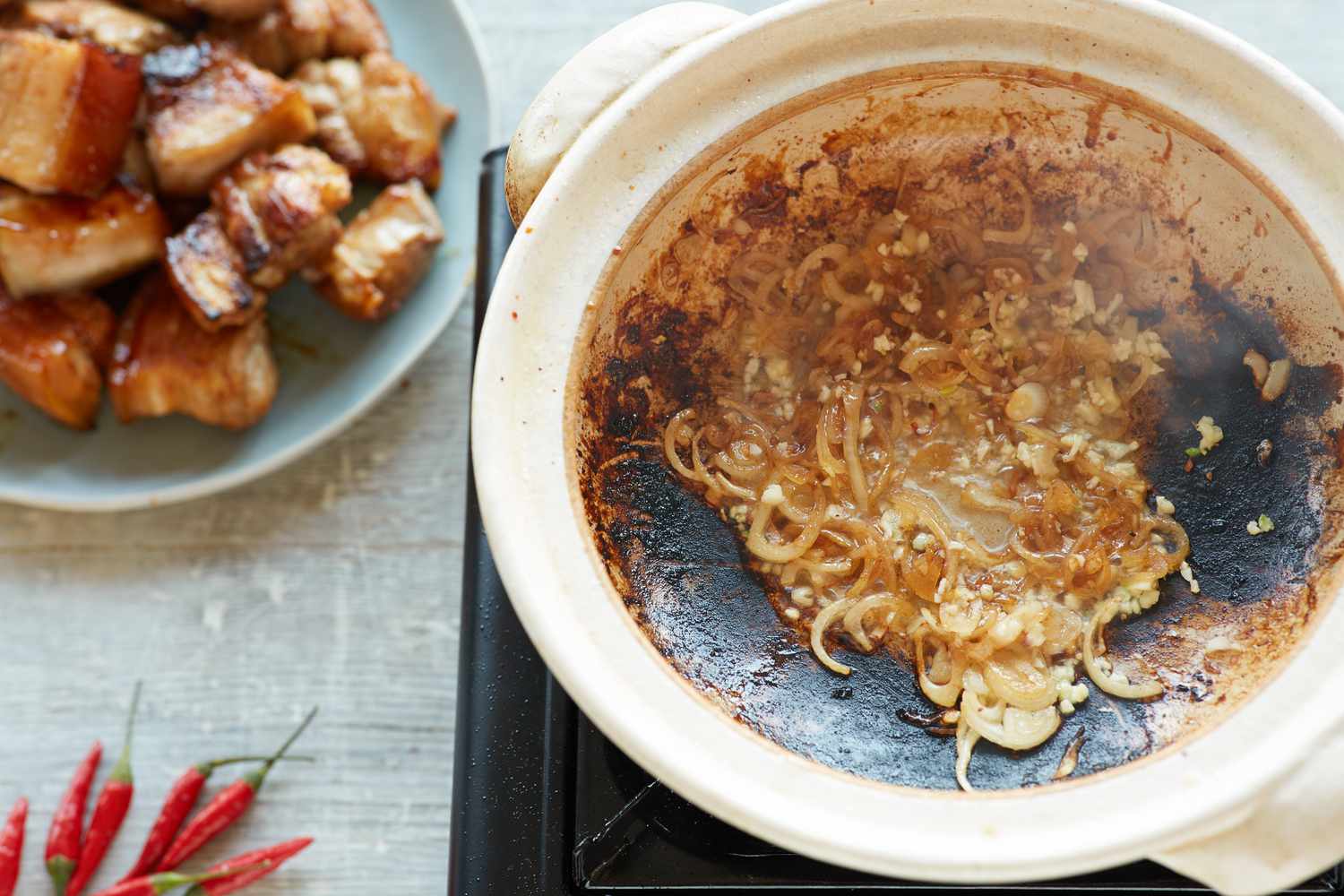 Aromatics sautéing in a pot to make sweet and savory braised pork belly 