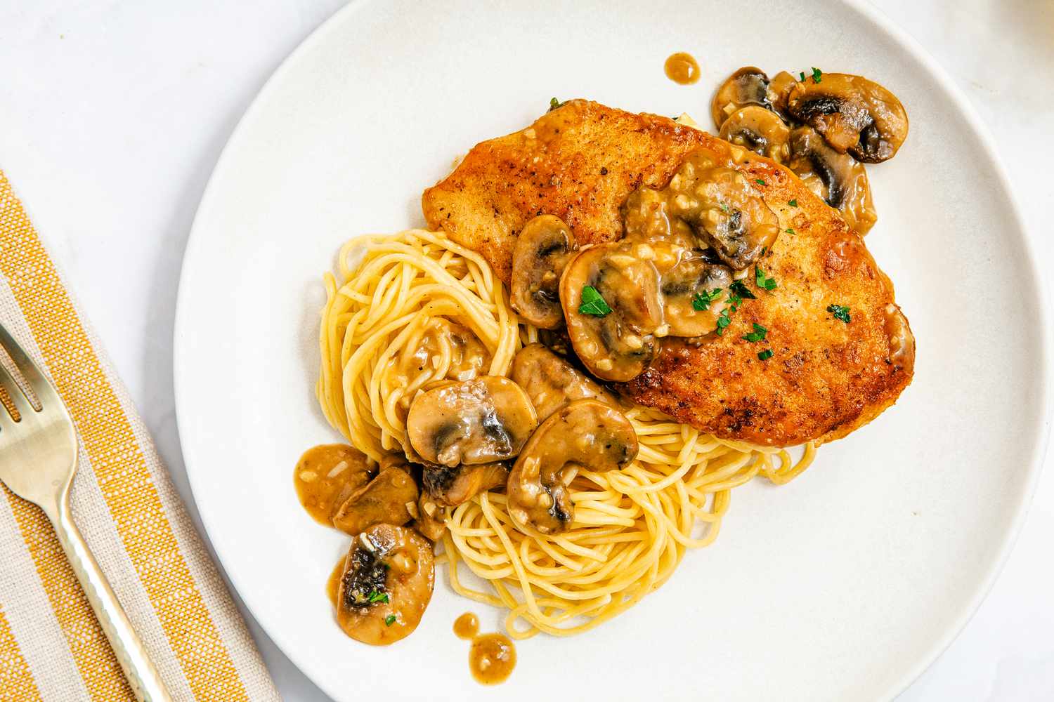 chicken marsala over spaghetti on a plate