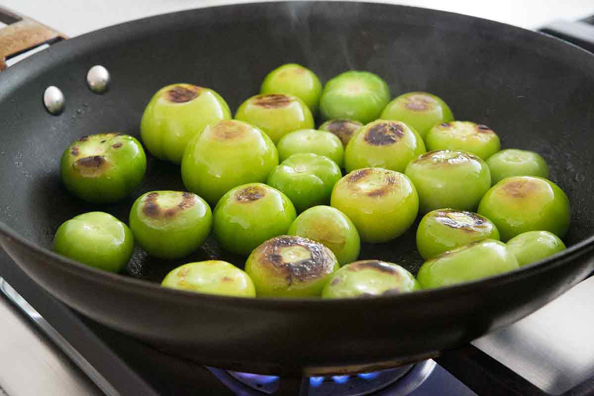 Tomatillos browning in a skillet