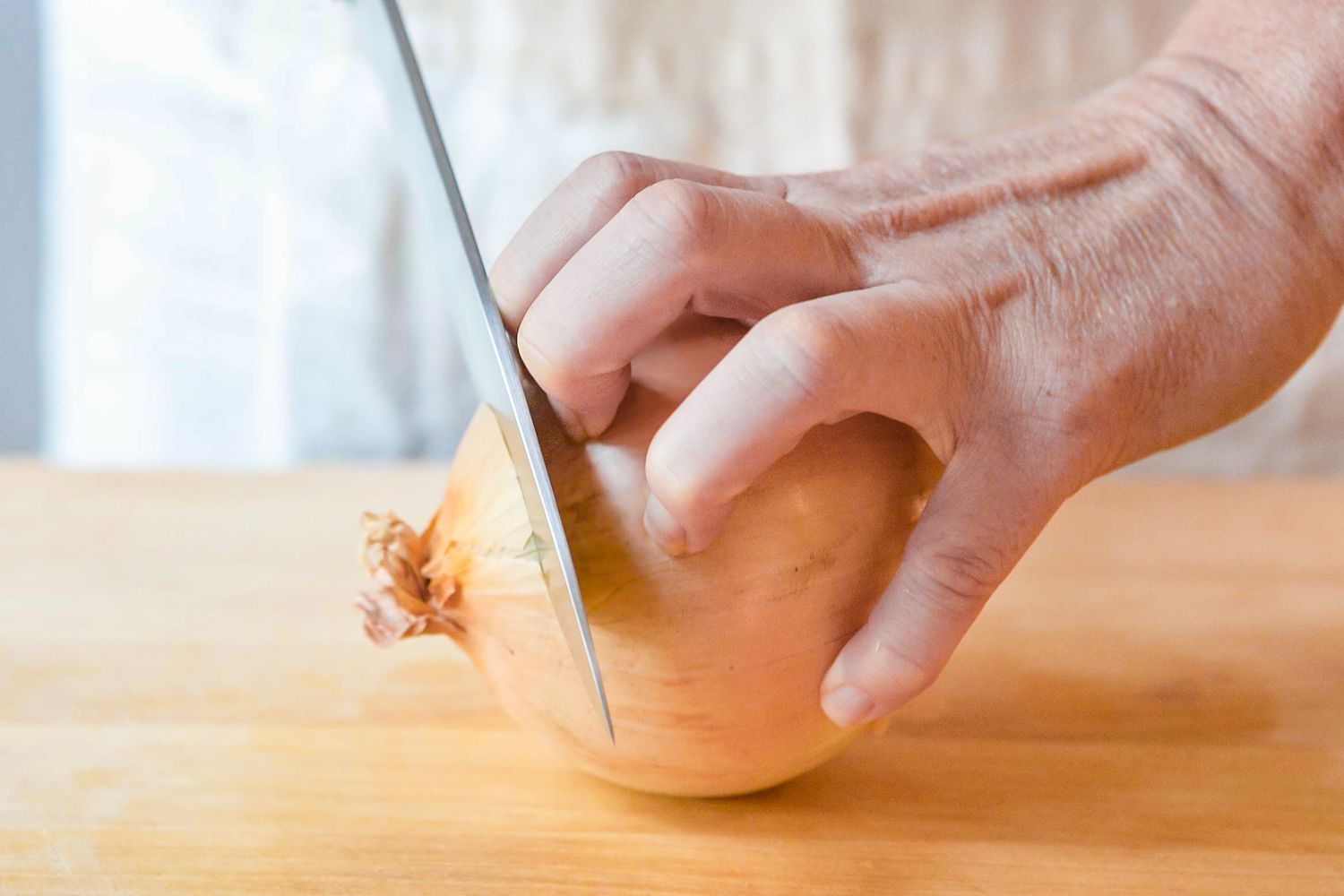 Onion Top Cut Off Using a Knife With the Other Hand Holding the Onion Firmly on the Cutting Board for How To Chop an Onion