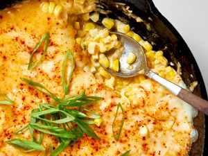 Close-up: Cast Iron Skillet With Korean Corn Cheese Topped With Sliced Green Onions and a Spoon (After Some of the Korean Cheese Corn Was Served)