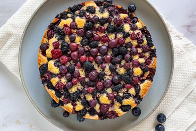 Blueberry Cake on a Plate With Rogue Blueberries on the Counter and Plate