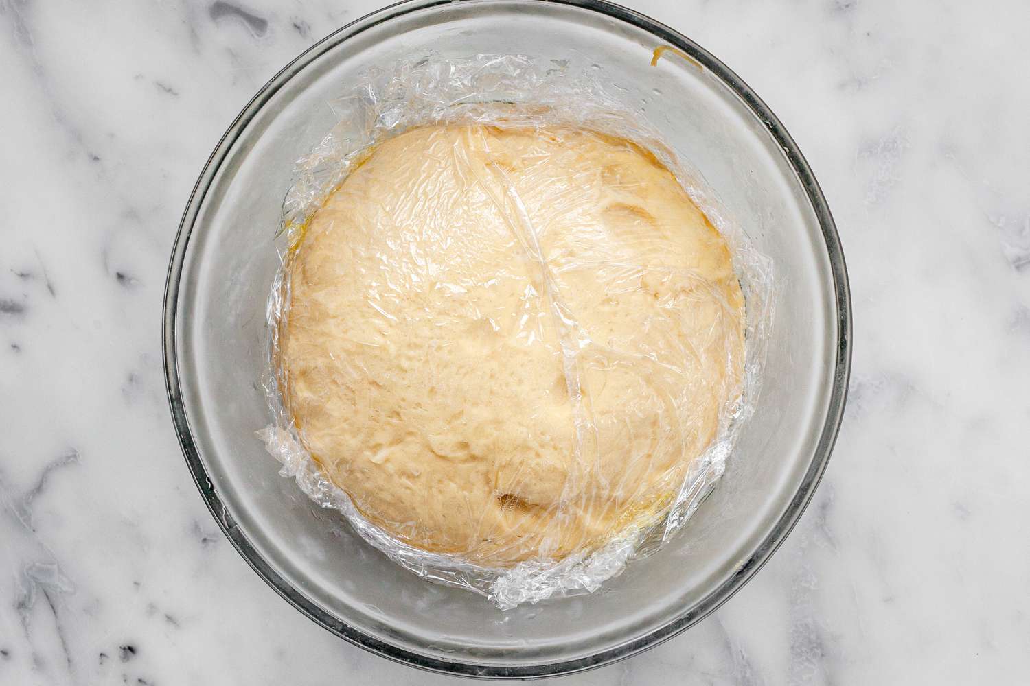 Brioche Sandwich Loaf Dough Resting in a Bowl Covered in Plastic Wrap
