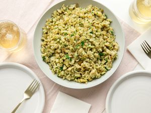 Bowl of Homemade Spaetzle (Spätzle) at a Table Setting with Two Drinks, Two Plates, and Forks on a Table Napkin