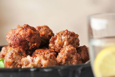 Plate with tasty sausage cheese balls on table