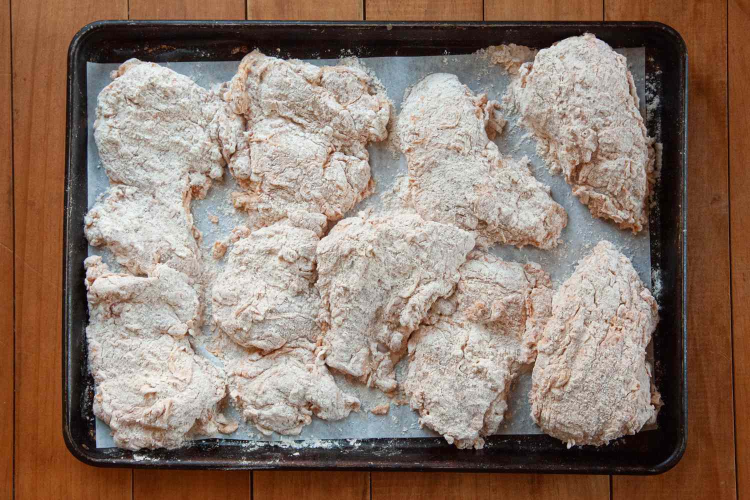 Breaded chicken on a baking tray to make Nashville-style hot chicken.
