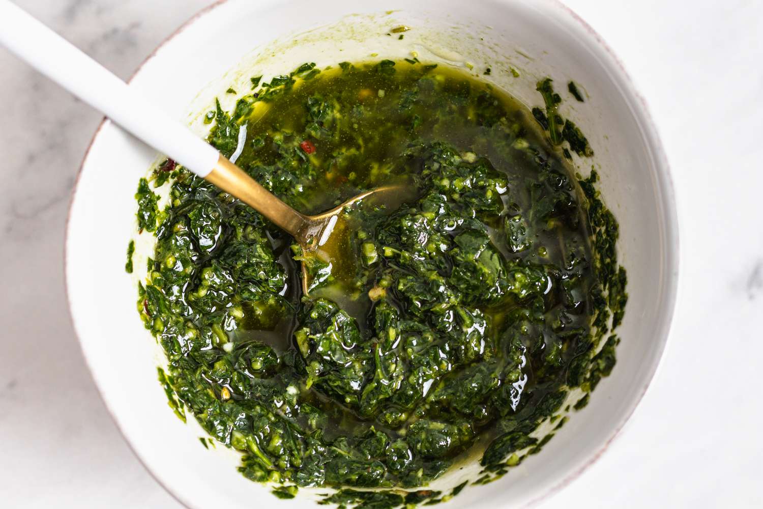 Chimichurri sauce in a bowl with a spoon.