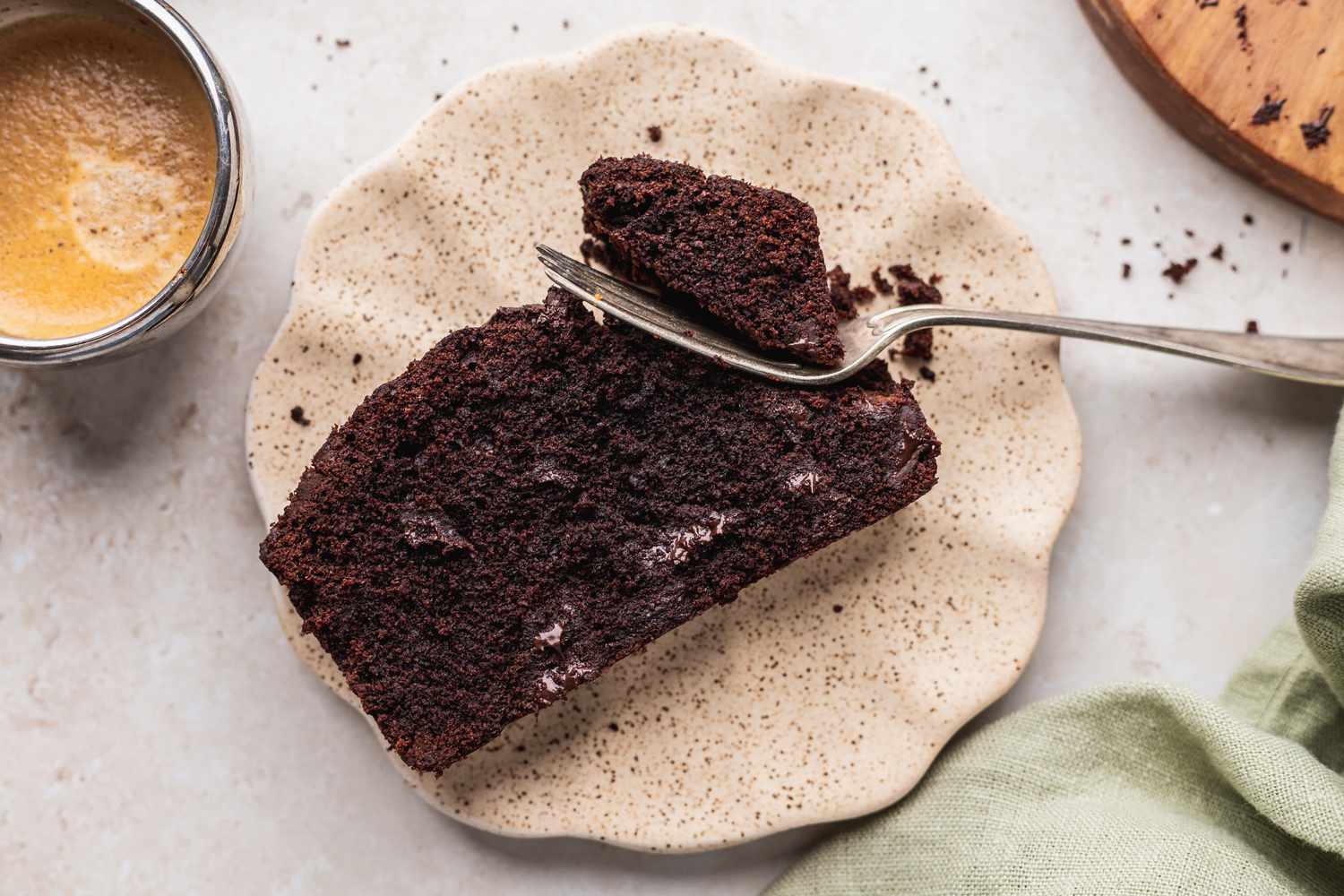 One slice of chocolate pound cake with fork on plate.
