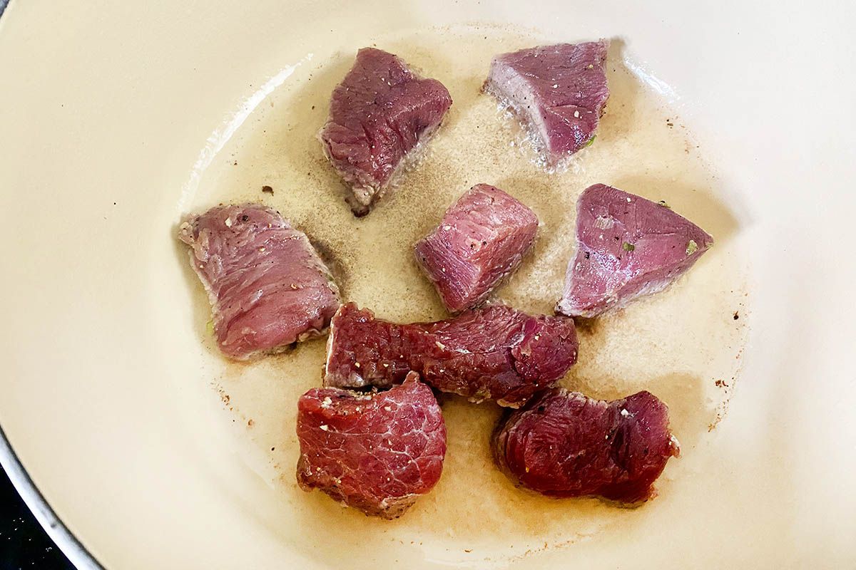 Beef in the bottom of the dutch oven to make a Jamaican Stewed Beef Recipe.