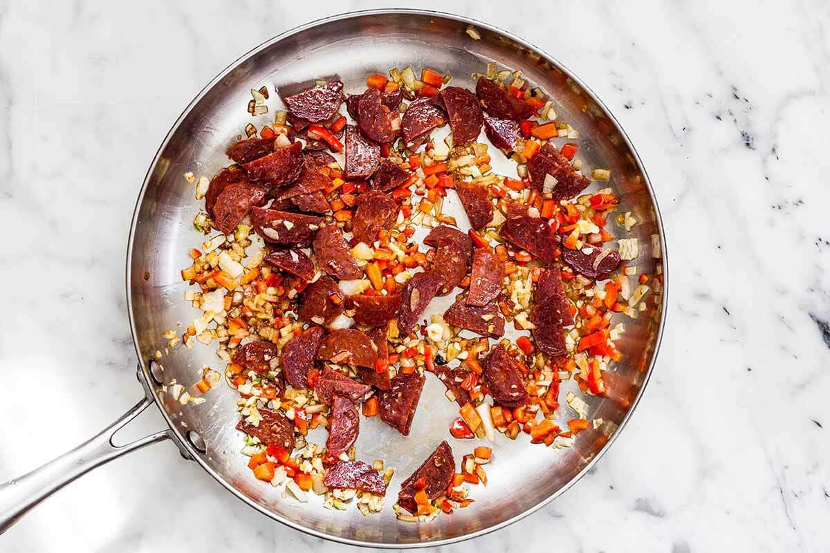 A soffrito base being cooked in a skillet