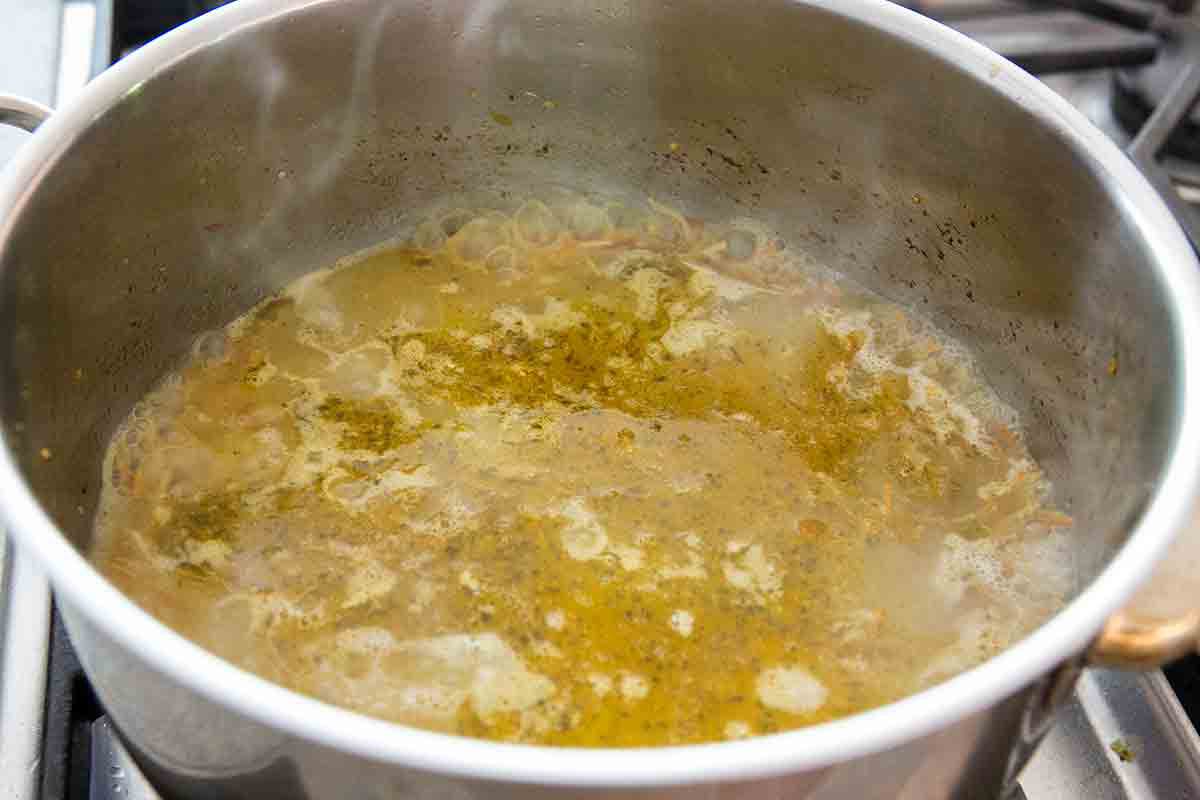add stock to pasta and tomatillo sauce in pot