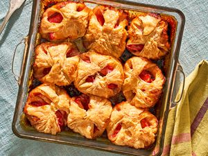 Peach dumplings in a glass pan on a blue tablecloth